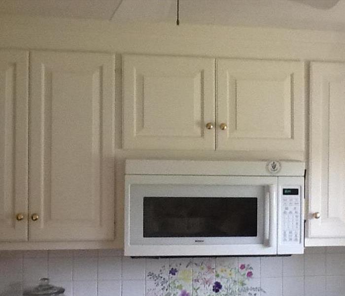 cream kitchen cabinets with a white microwave built in