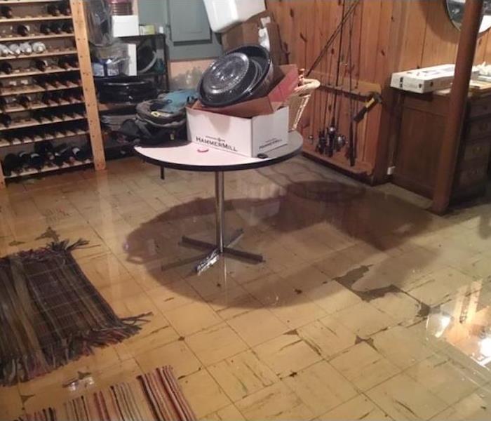 basement with standing water and items stacked on a table