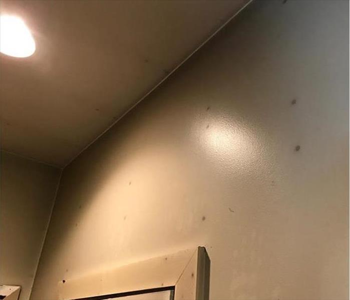 corner of a room showing soot on the walls and the spots of darker residues