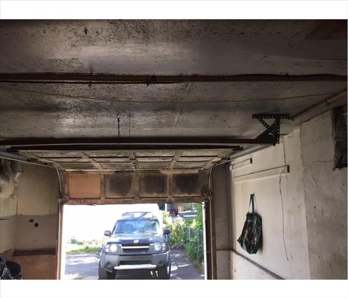 open garage door, soot inside, car in driveway