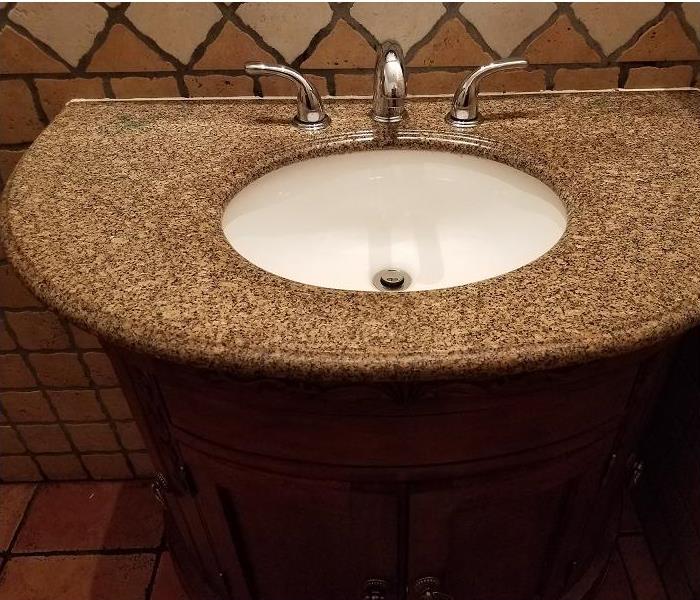 dark granite bathroom sink with cabinet